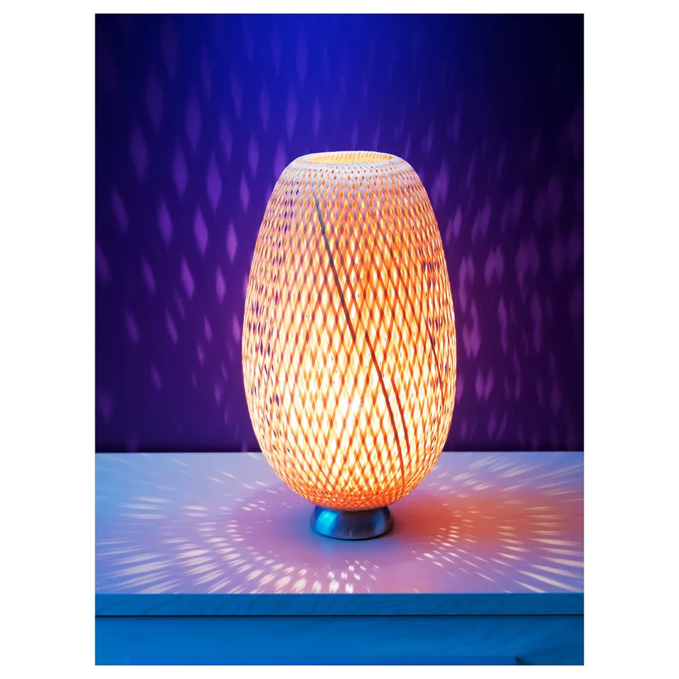 Bamboo lamp BÖJA, warm light, oval shape, intricate patterns.