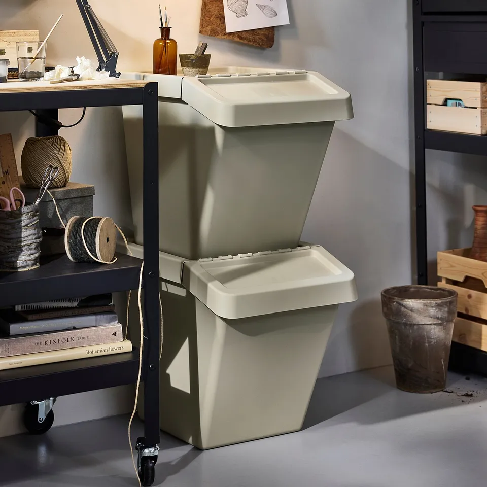 Two SORTERA bins with foldable lids on a craft workbench.
