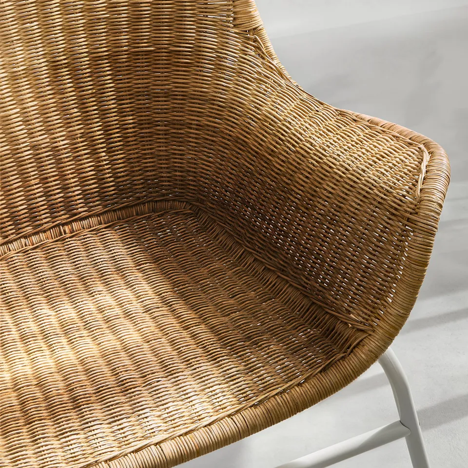 Close-up of woven rattan armchair, showcasing intricate design and durable craftsmanship.