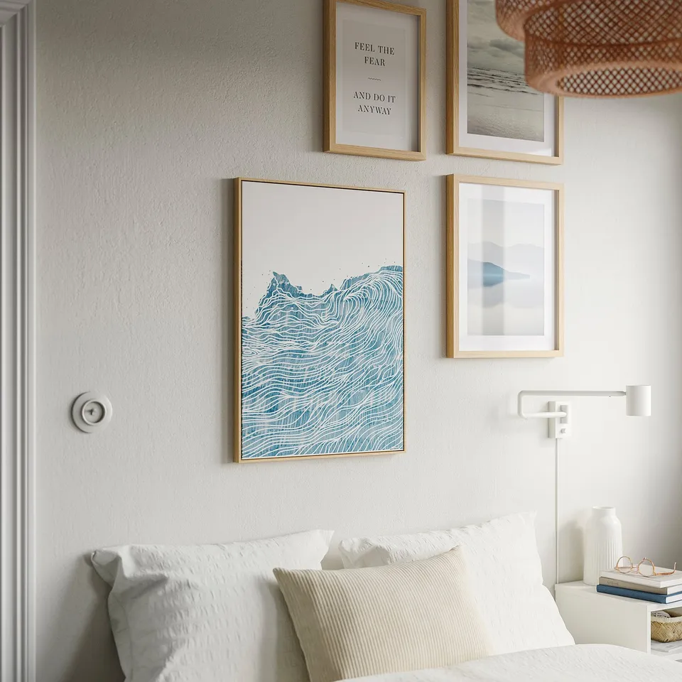 Bedroom wall with art gallery, BLODFLÄDER canvas central, white bed, wall light.