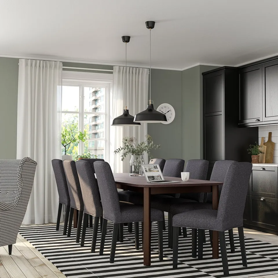Modern dining room with STRANDTORP table, 8 grey chairs, large window, green walls.