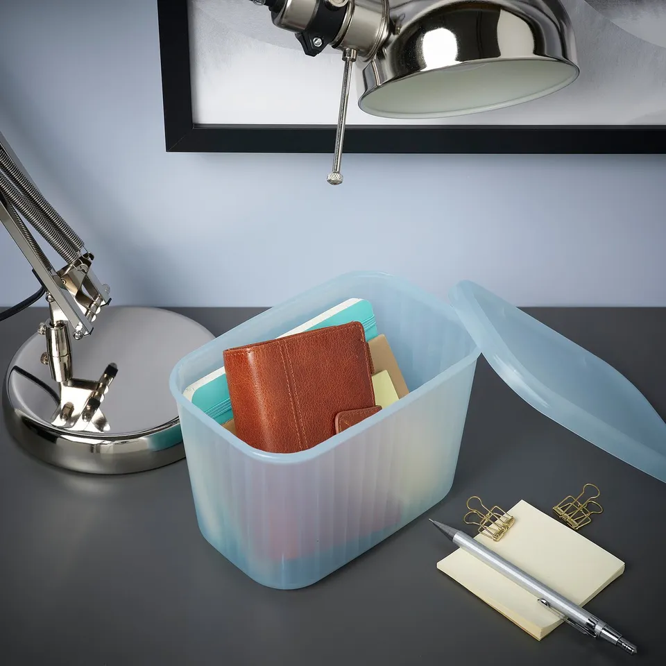 Desk with lamp, RYKTA organiser, pen, notepad, sticky notes, and binder clips.