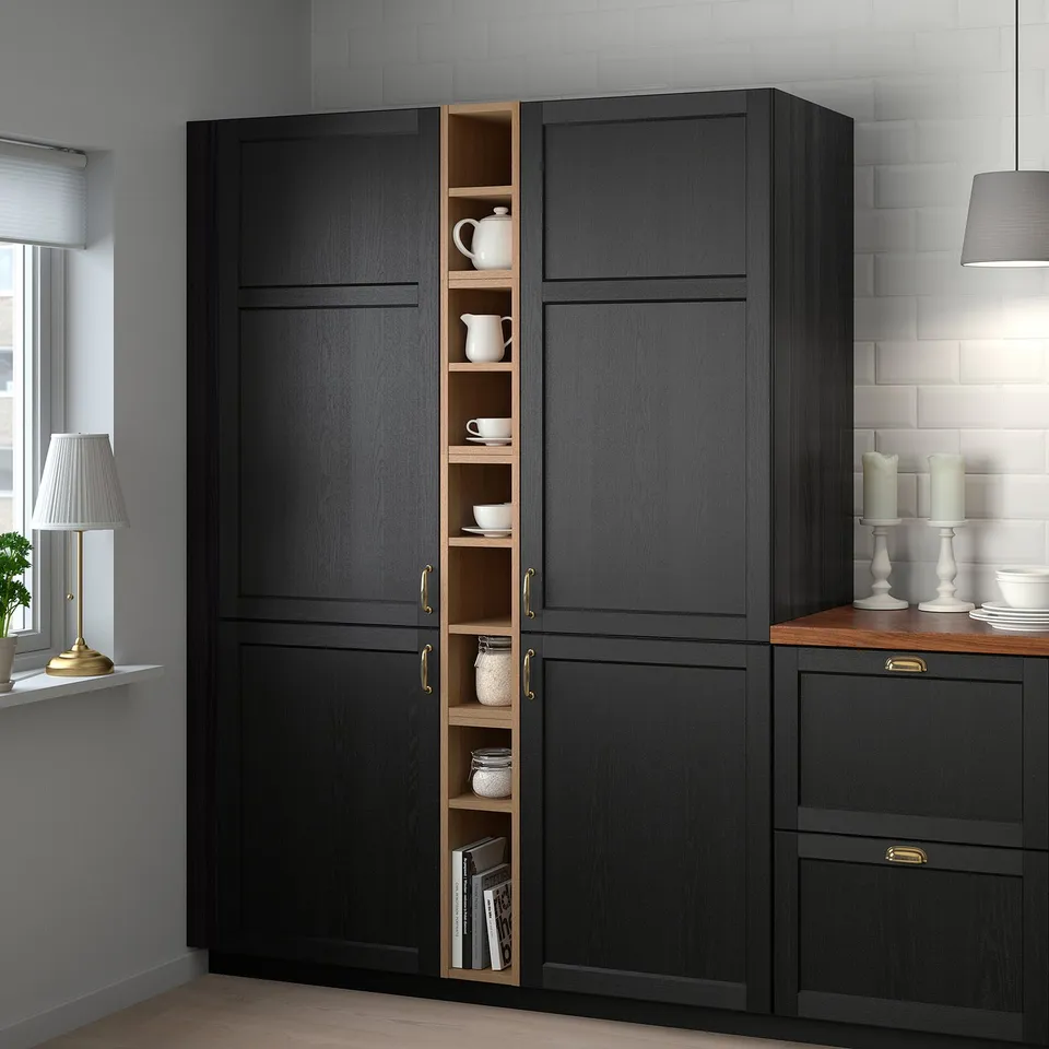 VADHOLMA black tall cabinet, wooden shelves, holds cups, jars, books. Tall, slim, fits kitchen corner. Gold handles.