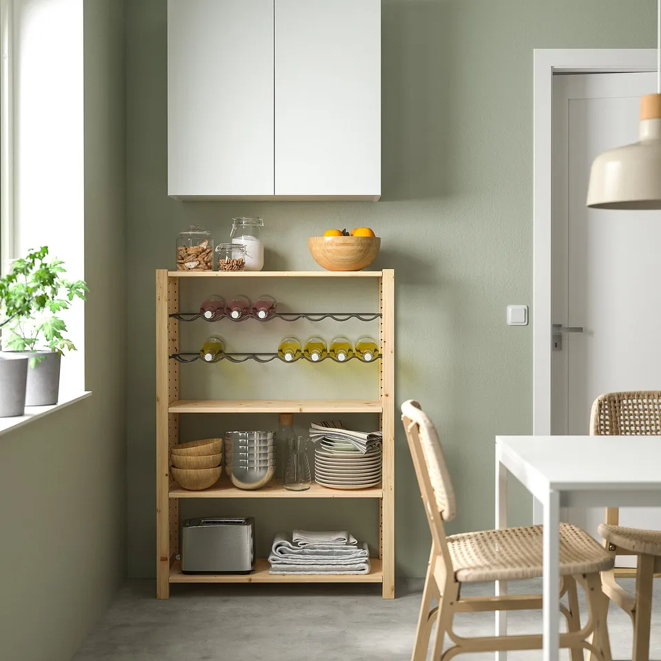 Modern kitchen with green IVAR unit, dishes, and fruit bowl.