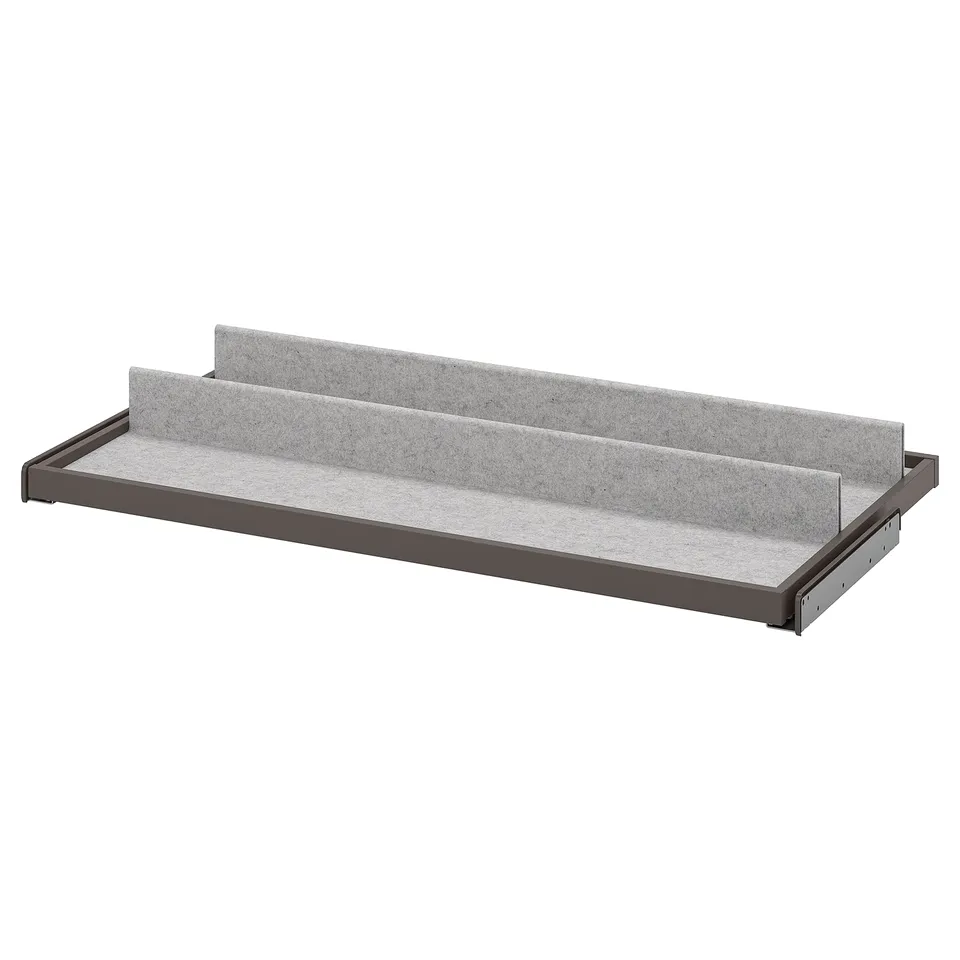 A grey KOMPLEMENT pull-out tray with felt lining for organising items in a wardrobe.