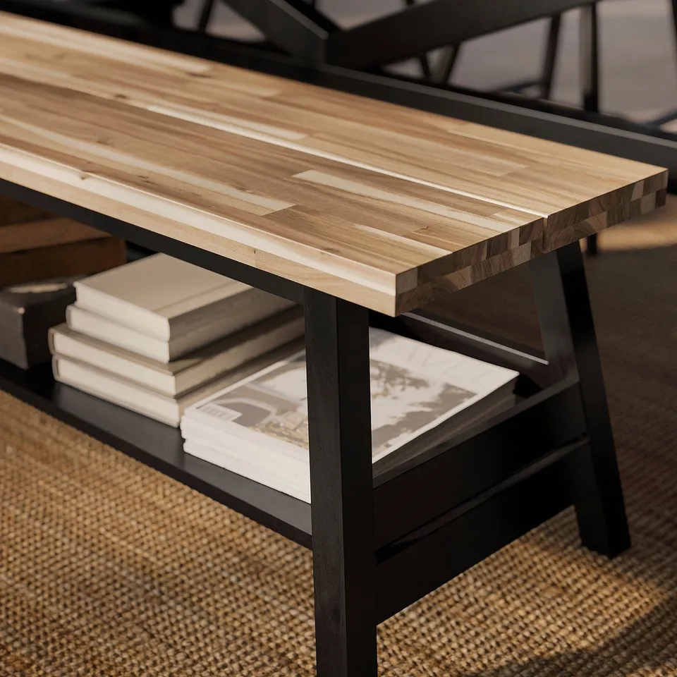 Wooden table with metal legs, shelf holding books and papers.