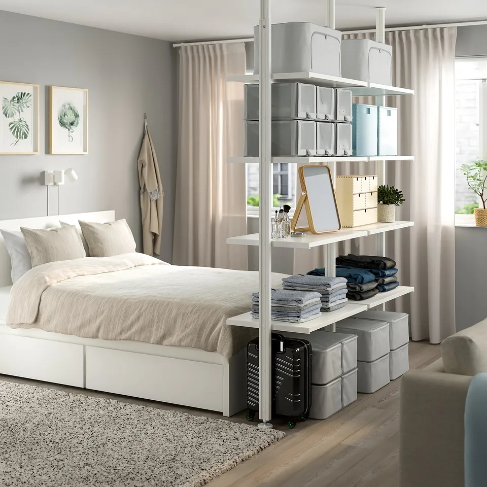 Modern bedroom with ELVARLI white storage unit, grey fabrics, plants, and art.