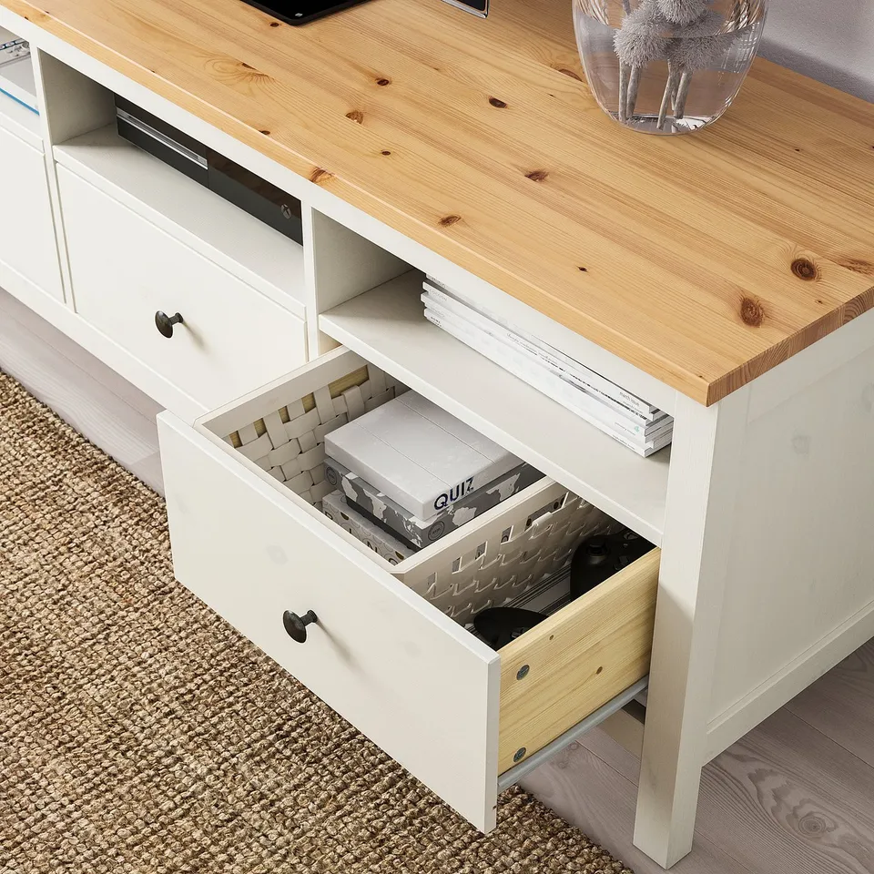 Wooden tv stand with drawer open, showing organised games and electronic storage.