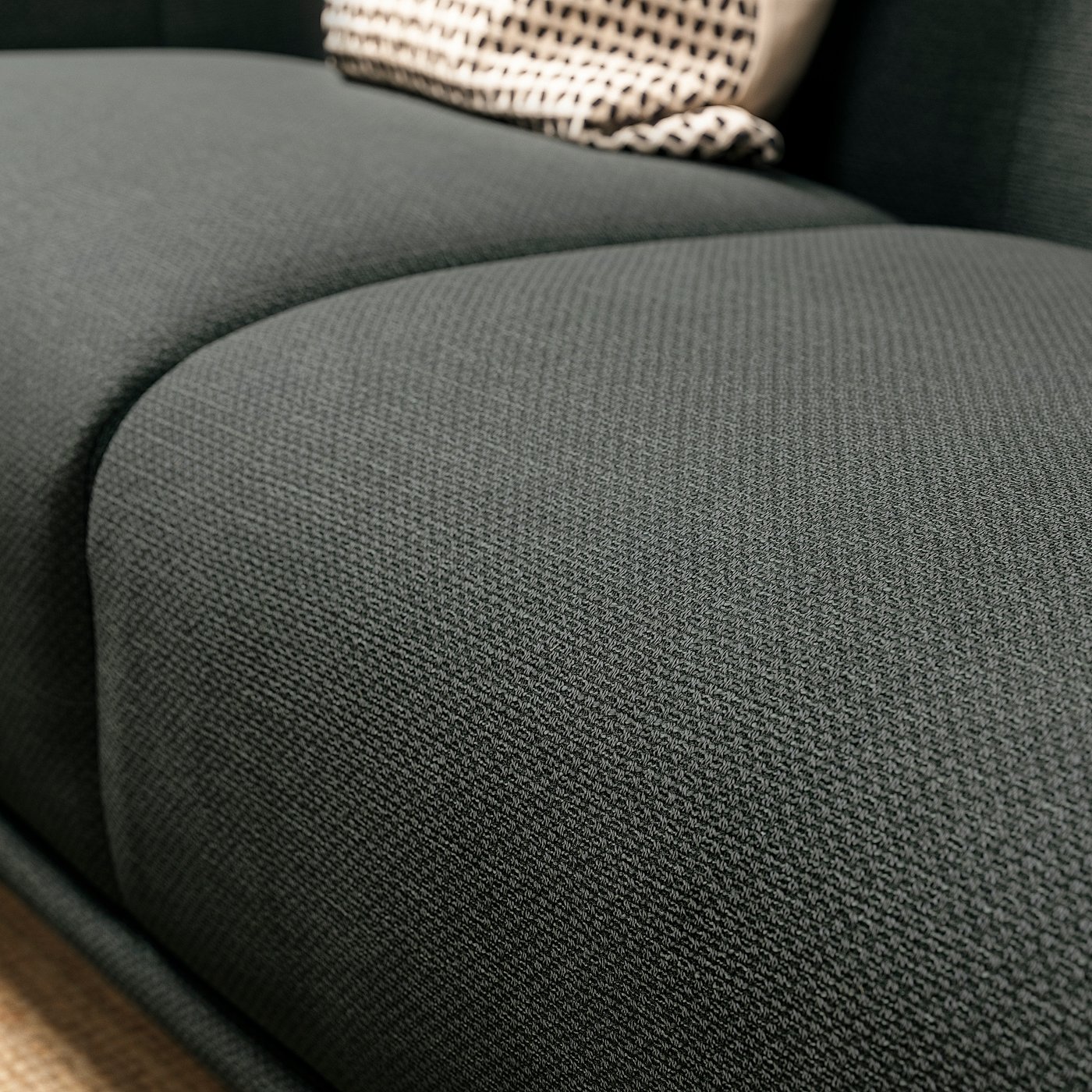 Dark green fabric sofa with cushy seat, sleek rounded edges.