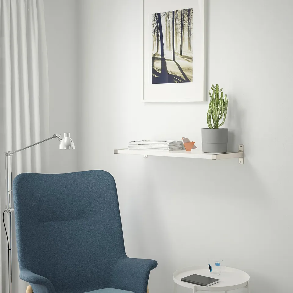 Home office: blue chair, desk with laptop, cactus, fox decor, wall print, lamp, compact setup.