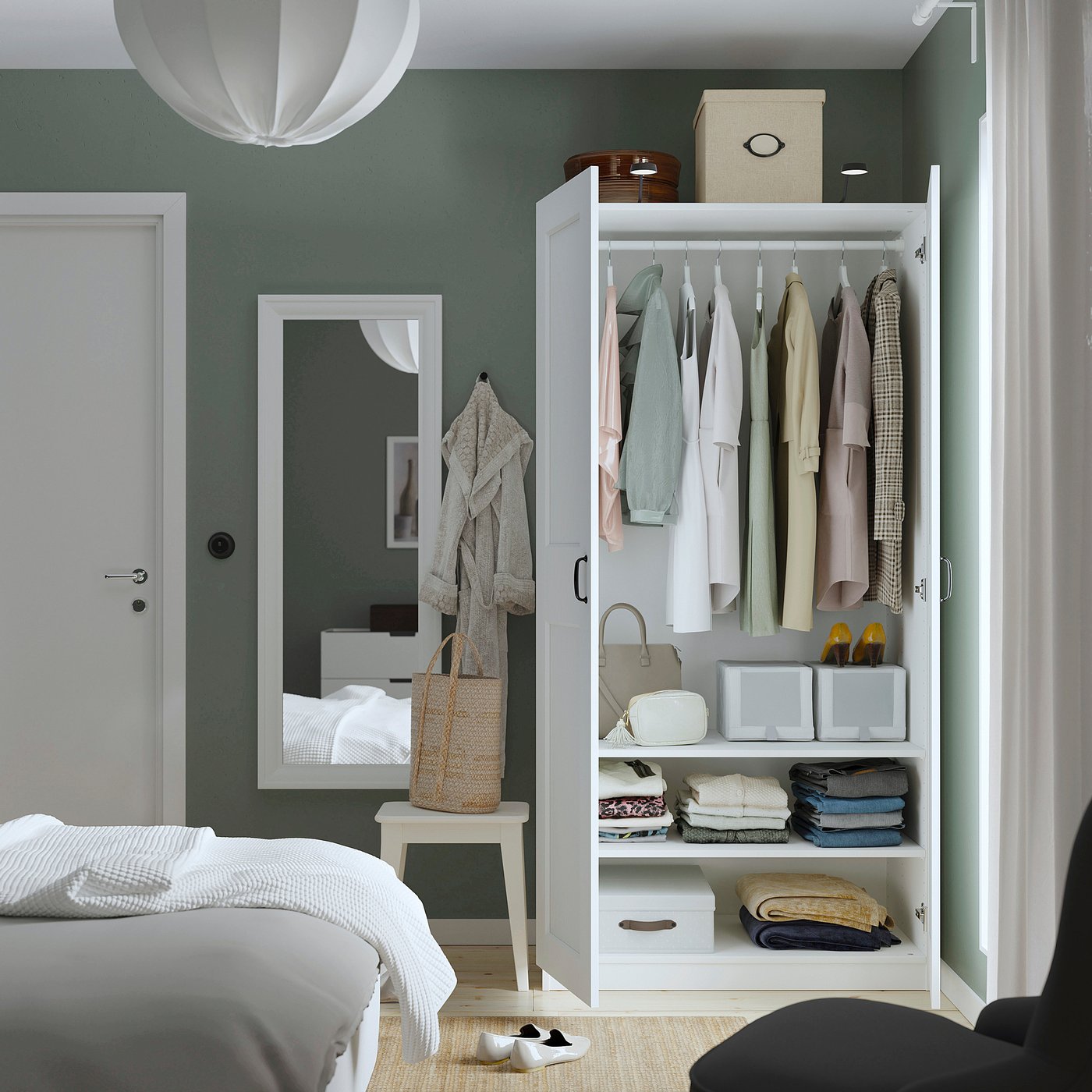 Bedroom with PAX wardrobe displaying clothes, accessories, and storage boxes. Mirror, bed, and pendant light also visible.