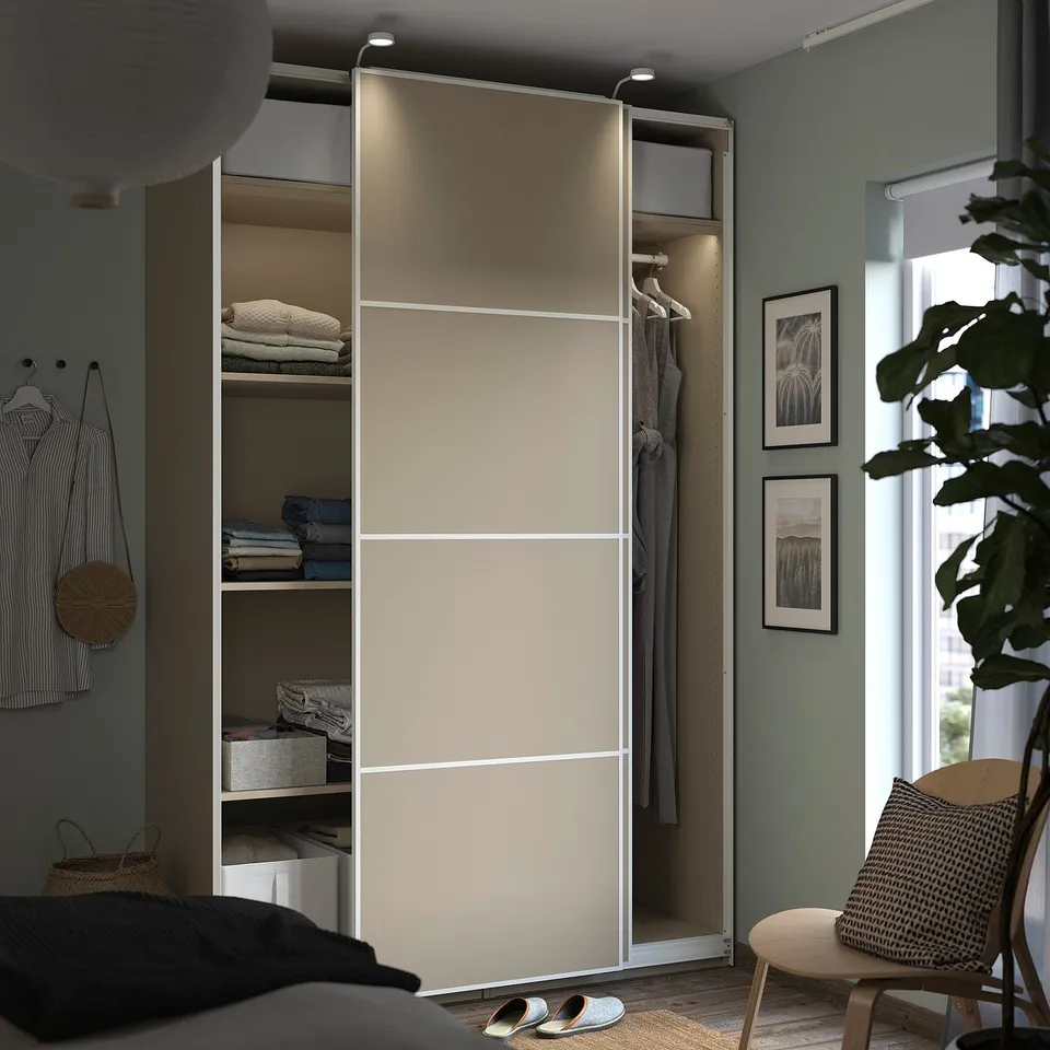 Beige PAX wardrobe in modern bedroom with decor, clothes.