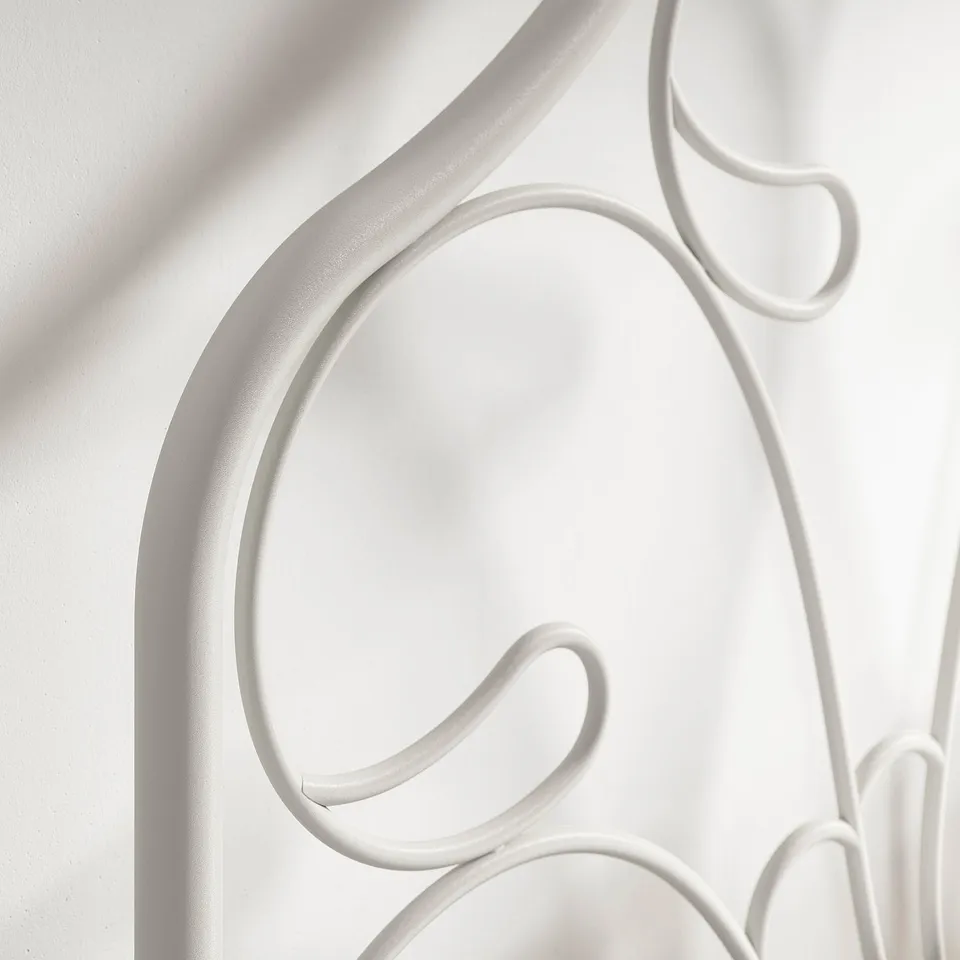 White metal bed frame with elegant, smoothed curves and sturdy appearance.