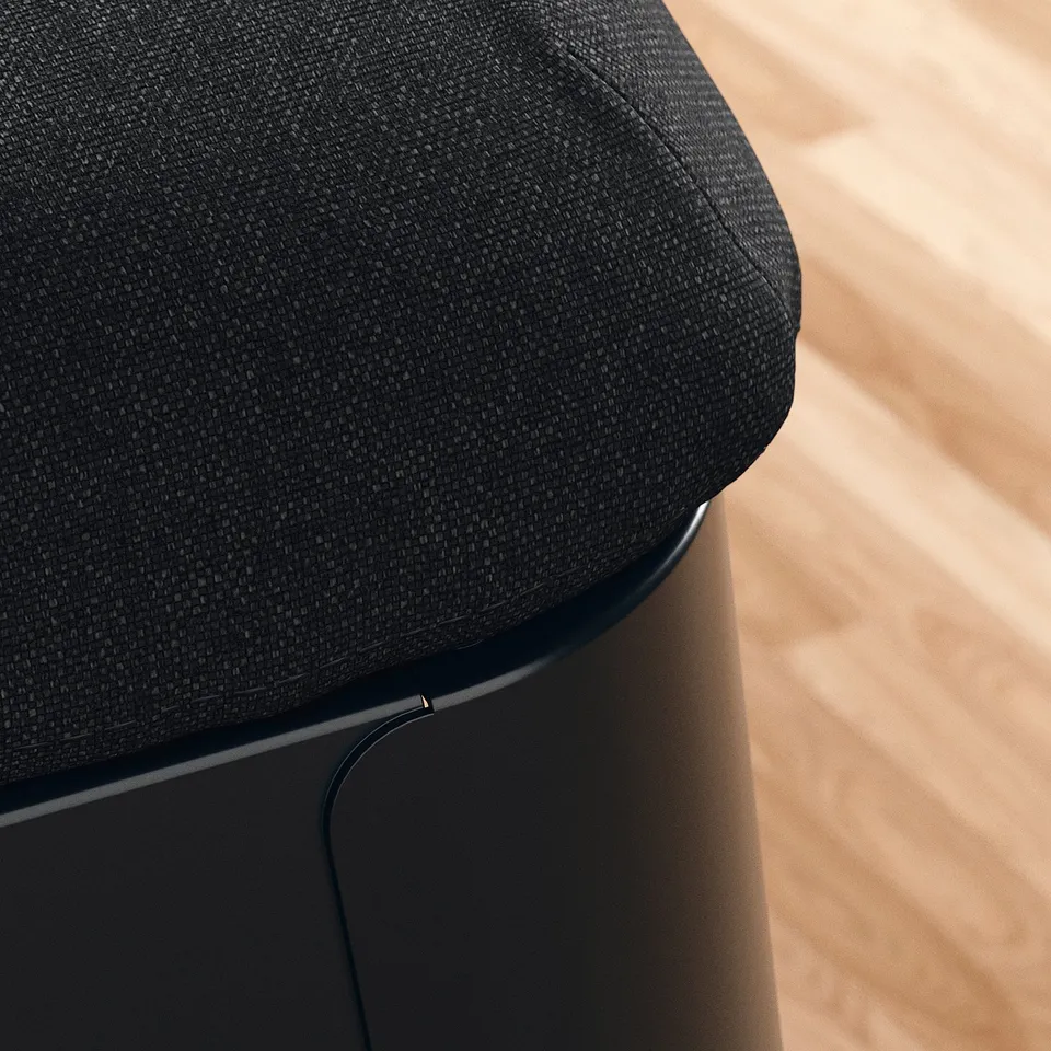 Close-up of a plush, black fabric-covered cushion on a modern, sturdy chair, showcasing high-quality upholstery and craftsmanship.
