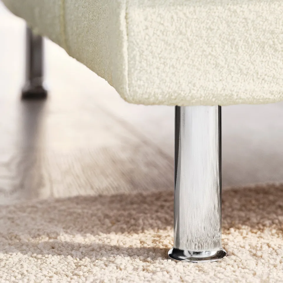 UPPÅKRA sofa leg detail. Chrome-finished metal leg supports luxurious, soft, ivory bouclé fabric. Durable and stylish.