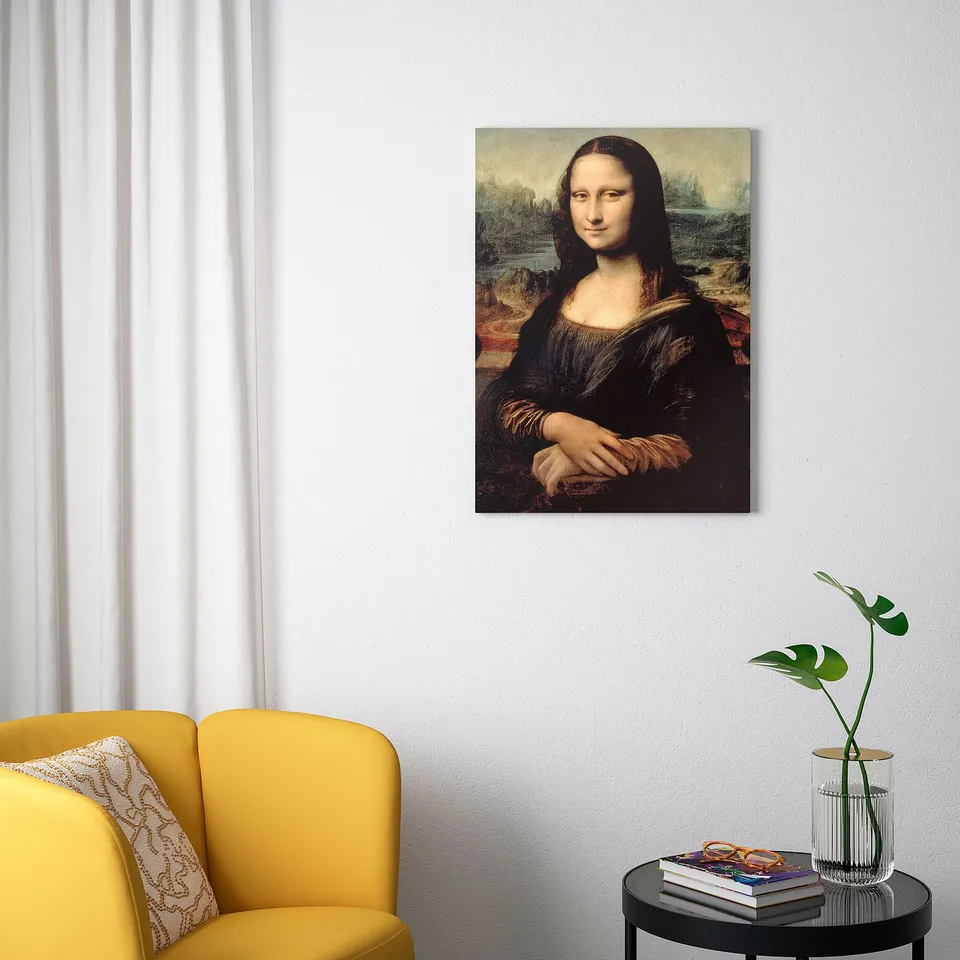 Living room with PJÄTTERYD print, yellow couch, books, plant.