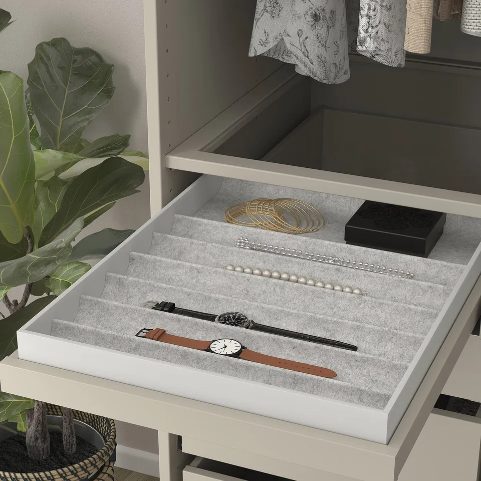 Pull-out jewellery tray with compartments, displaying watches, necklaces, and bracelets on felt-lined shelves.