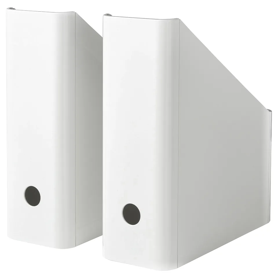 Two white KUGGIS magazine holders side-by-side, made of recycled pet plastic, featuring a circular cut-out and angled design for easy access.