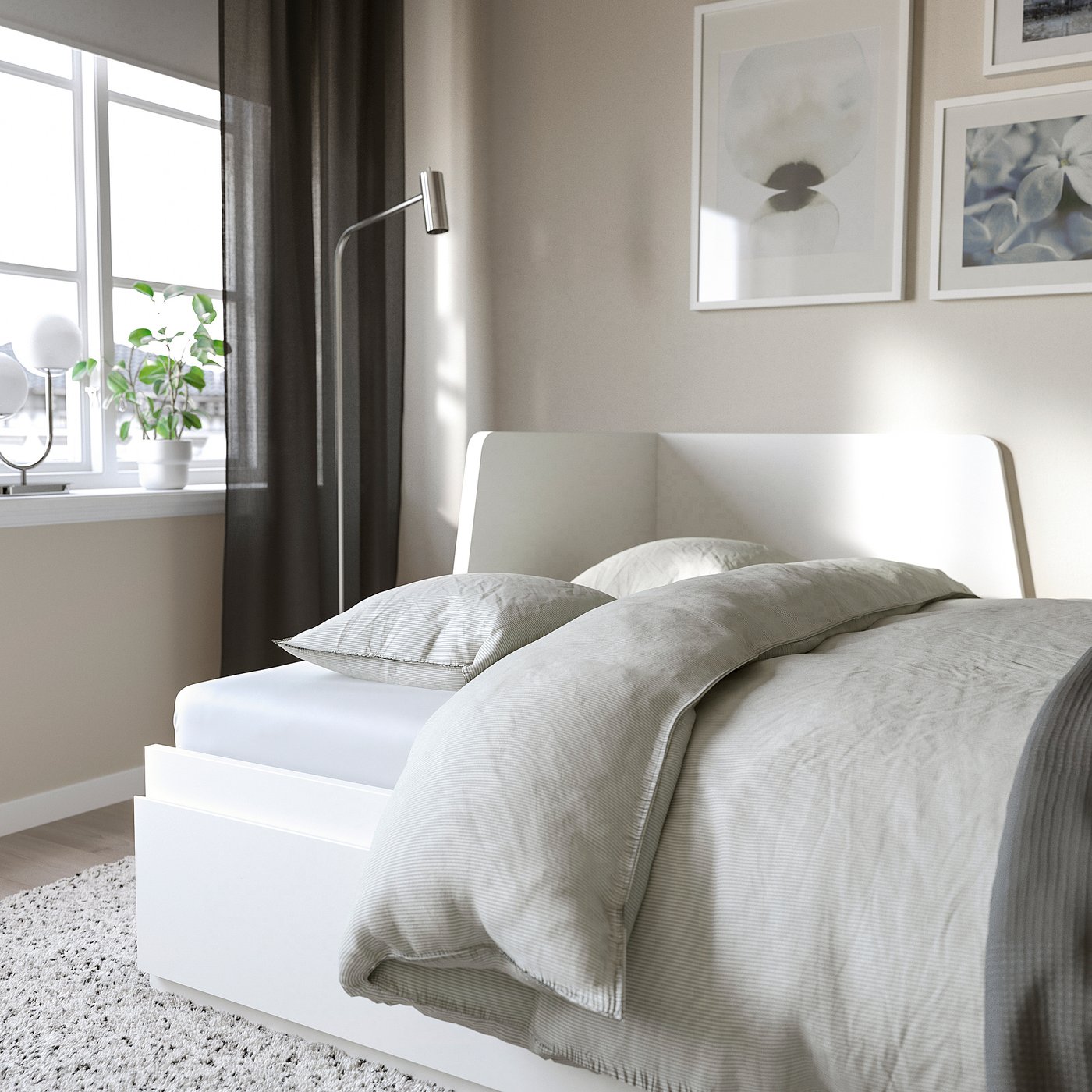 Modern bedroom with grey bed, pillows, and art, functional day-bed with drawers.