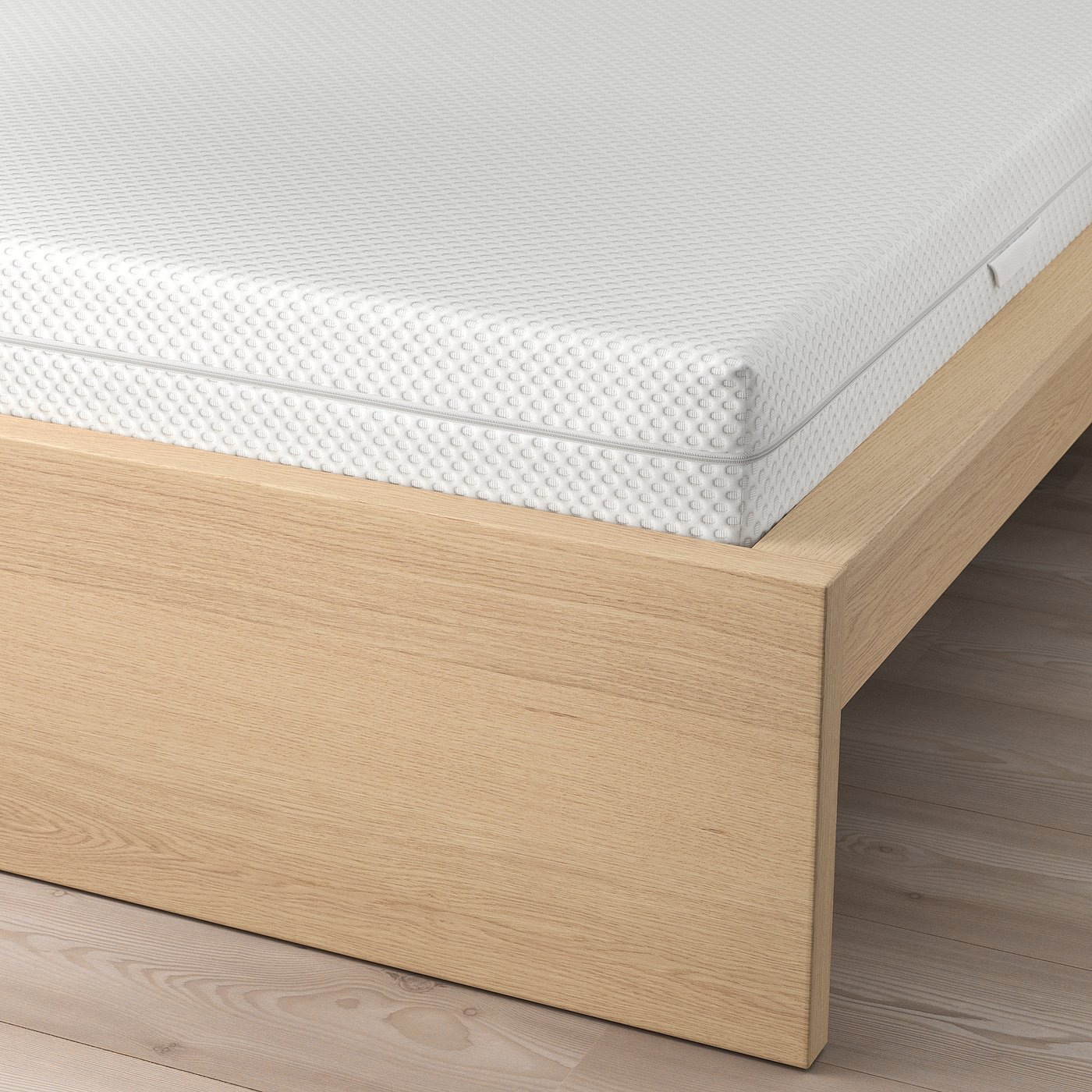 A bed with a white textured mattress on wooden slats, part of the MALM series, designed for comfort and support.
