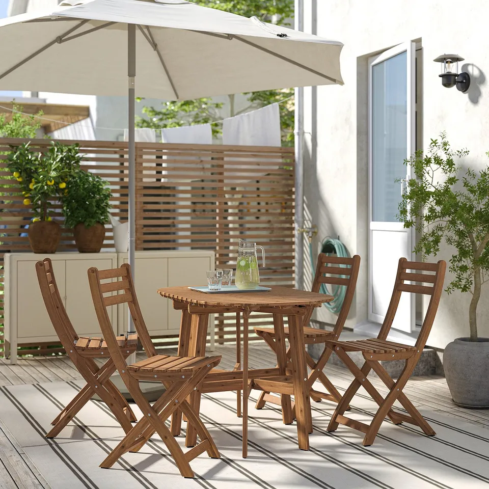 Acacia table with 4 folding chairs, umbrella, plants, drinks - outdoor dining set.