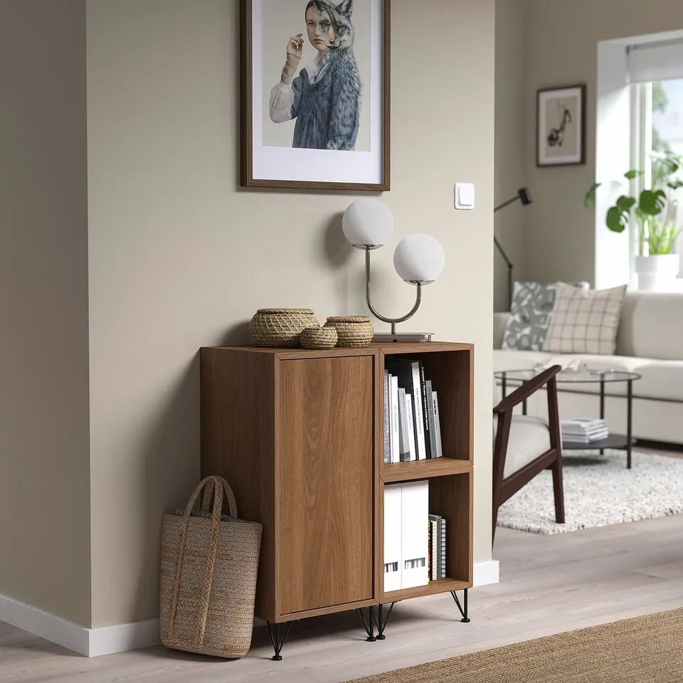 Modern living room with EKET side unit, books, bag, lamps, picture, couch, basket.