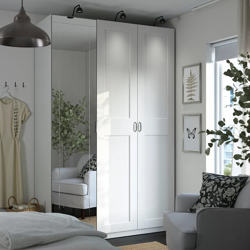 Modern bedroom with PAX wardrobe, mirrored and white doors, central lighting.