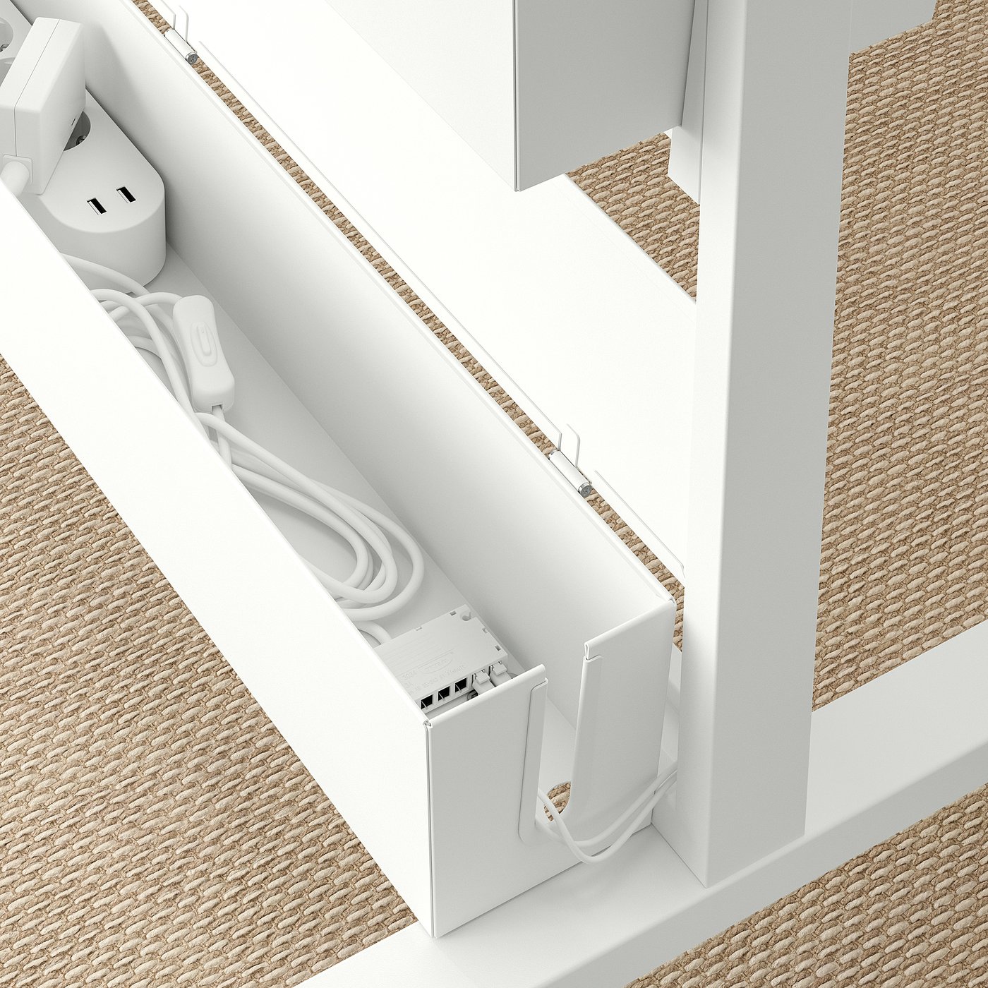 White cable box with open door displaying connectors and coiled cables next to desk on beige floor.