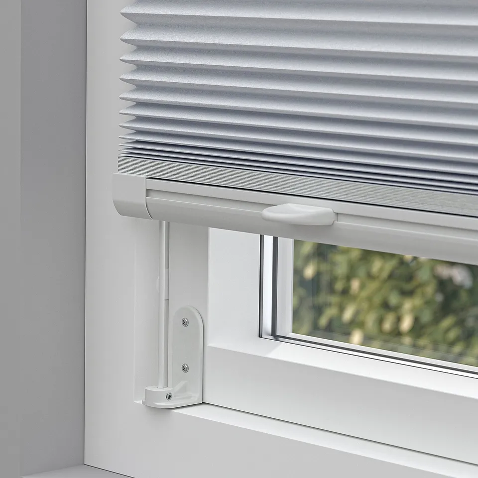 Window with cordless pleated blind, adjustable from top or bottom, mounted on side.
