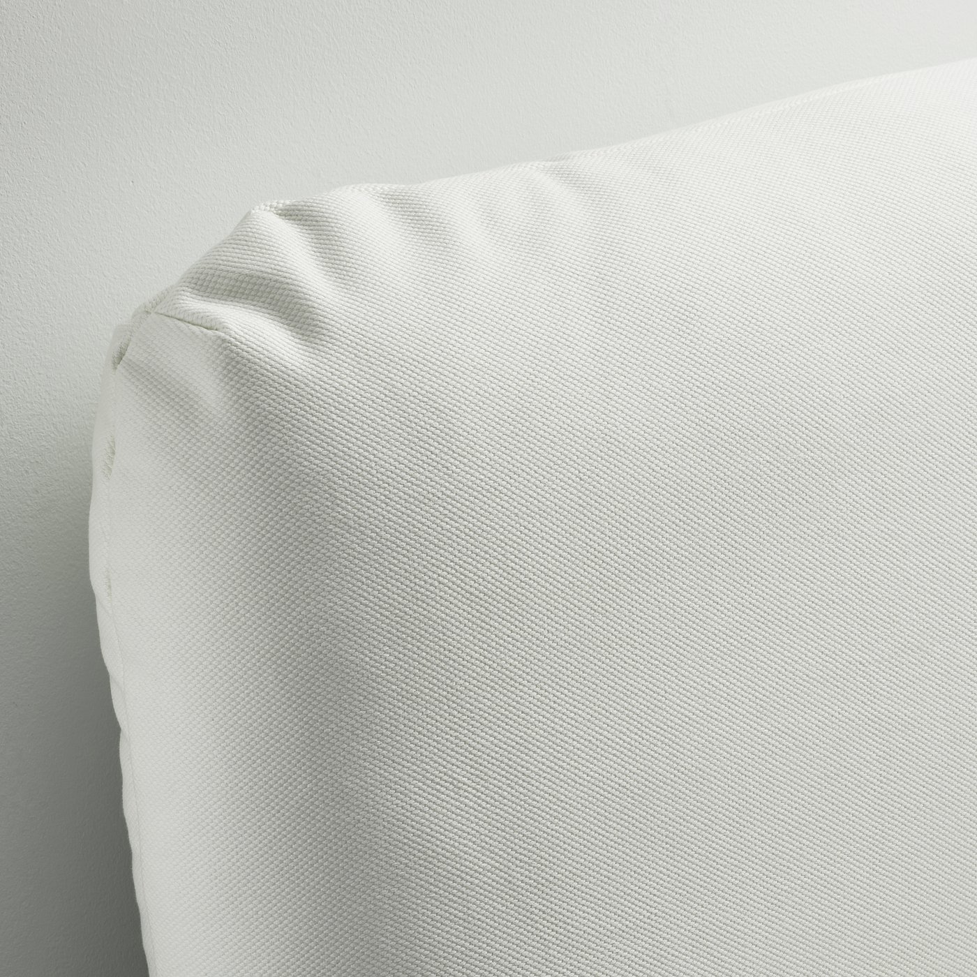 A plush, white bed frame with neatly arranged pillows, showcasing high-quality upholstery and inviting comfort.
