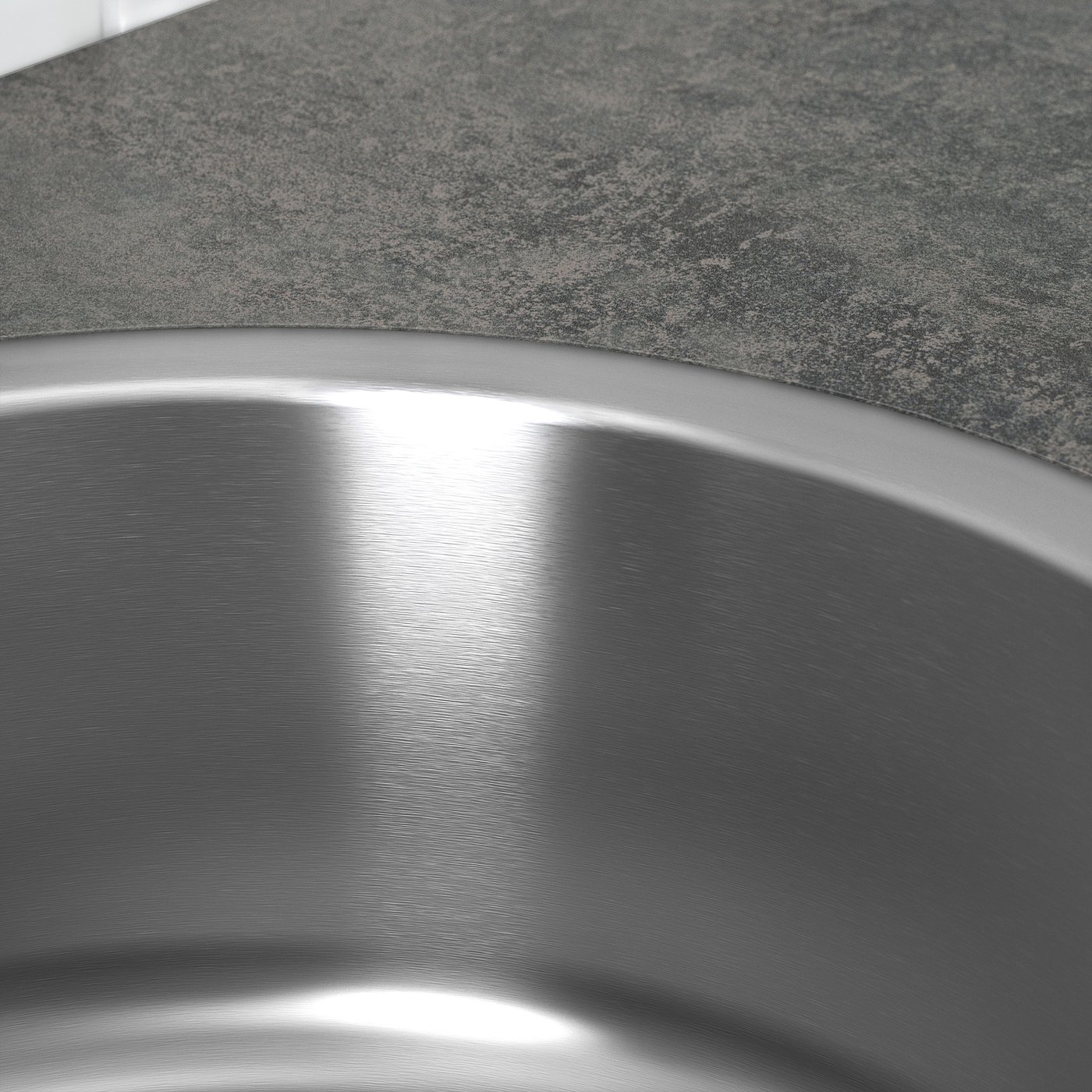 Stainless steel sink close-up, polished finish reflecting light, set on granite countertop.