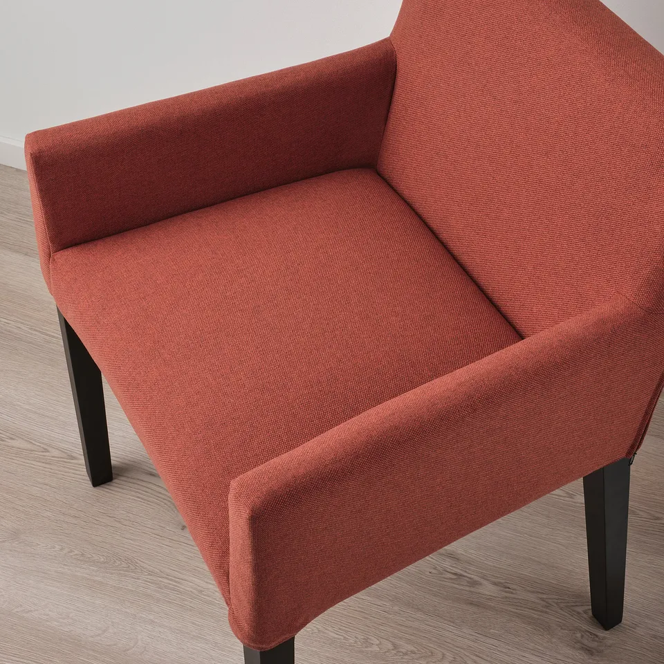 Comfortable red armchair with black legs on light wood floor.