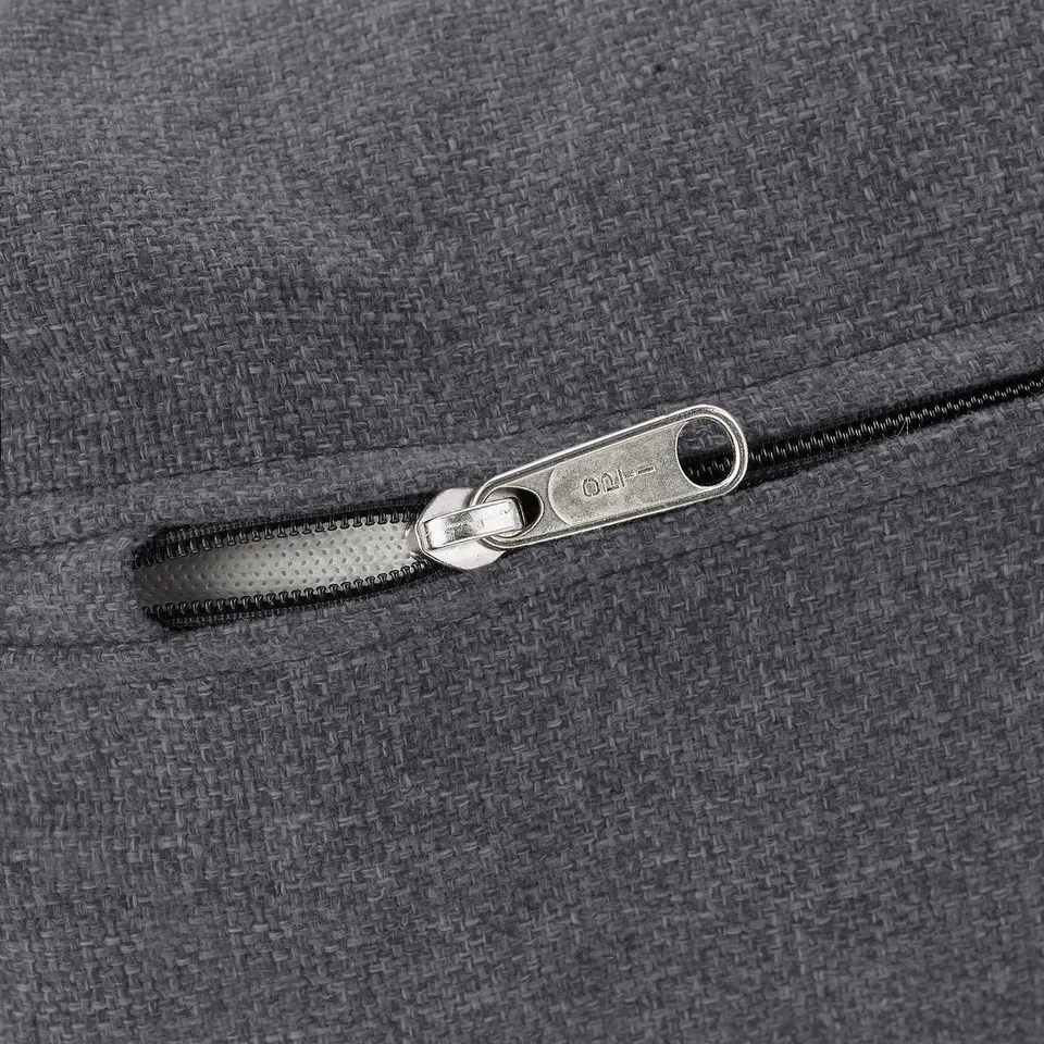 Close-up of high-quality grey zip on soft, textured cushioned material, showcasing detailed metal slider, indicating durable design.