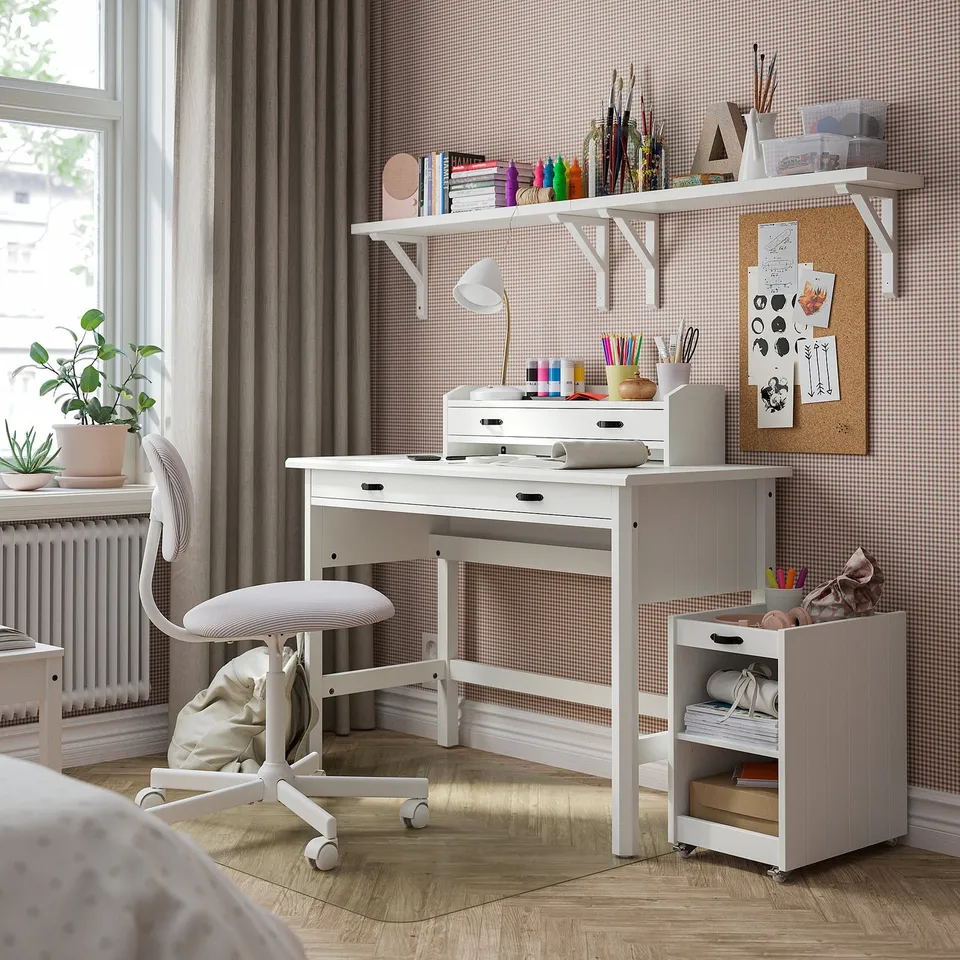 White BRYTNING desk & chair with storage, art supplies, and plant.
