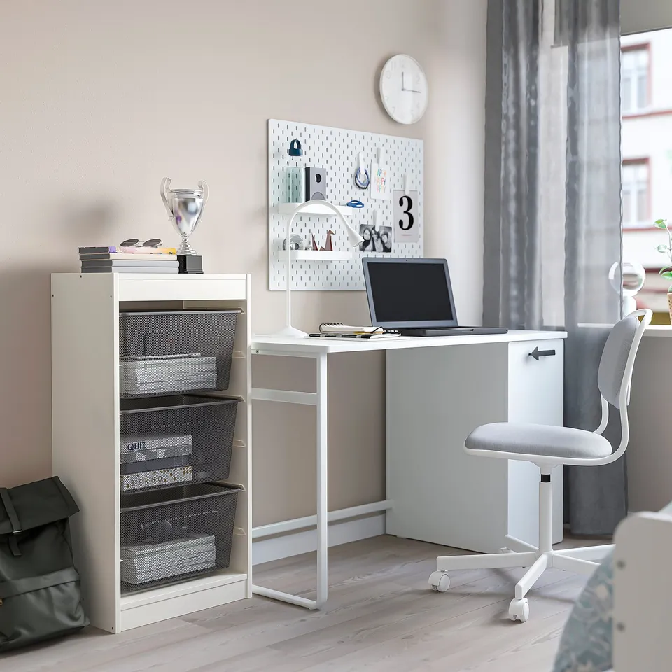 White TROFAST storage desk combo with laptop, chair, and wall decor.
