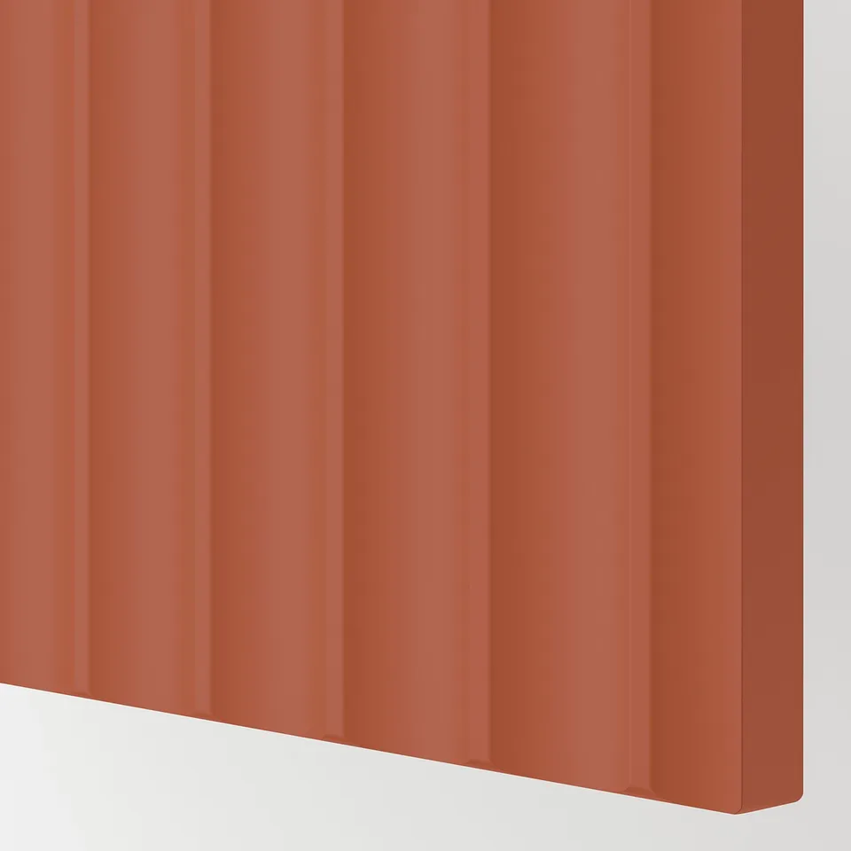 Fluted orange-brown kitchen cabinet close-up, smooth finish, clean design.