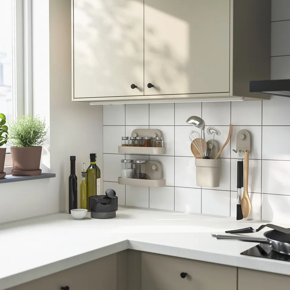 Modern white kitchen with light grey ÖBONÄS wall organisers holding jars and utensils, complementing the clean, minimalist decor.