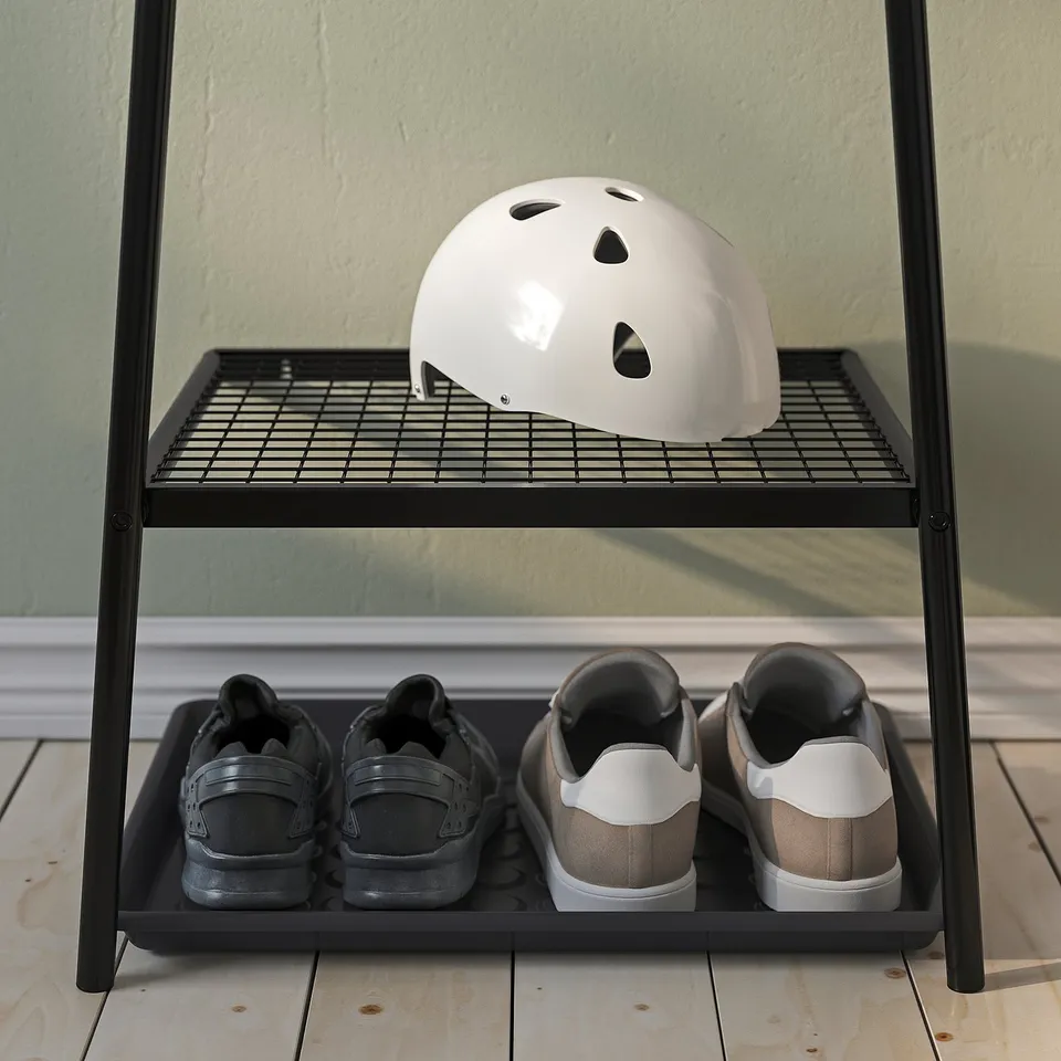 Black metal shoe rack with top helmet storage; ideal for narrow spaces.