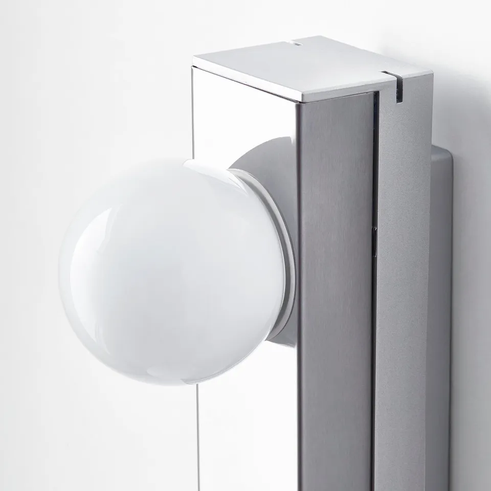 Modern wall-mounted light fixture with a large, round, frosted glass shade, showcasing sleek design and quality craftsmanship.