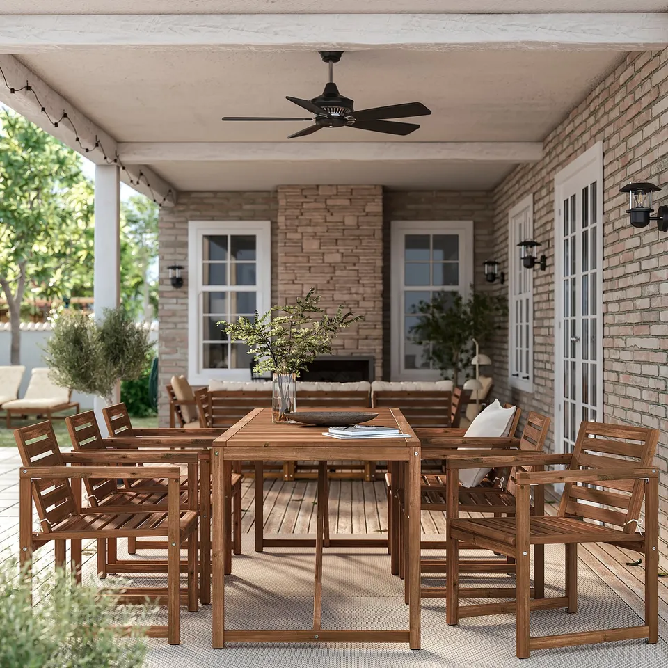 Large wooden patio set with table and chairs. Bright brown colour. Handles several people. Under brick house porch.