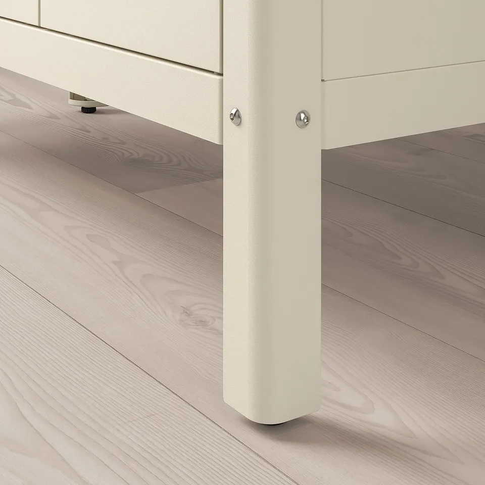 Close-up of a white metal cabinets corner, showcasing sturdy, adjustable feet and robust construction.