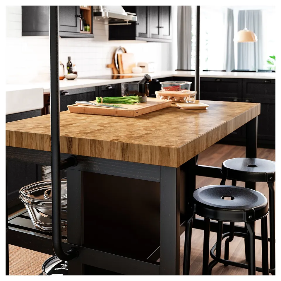 Modern kitchen island, VADHOLMA, with butcher block top and black metal frame. Includes storage and two stools.