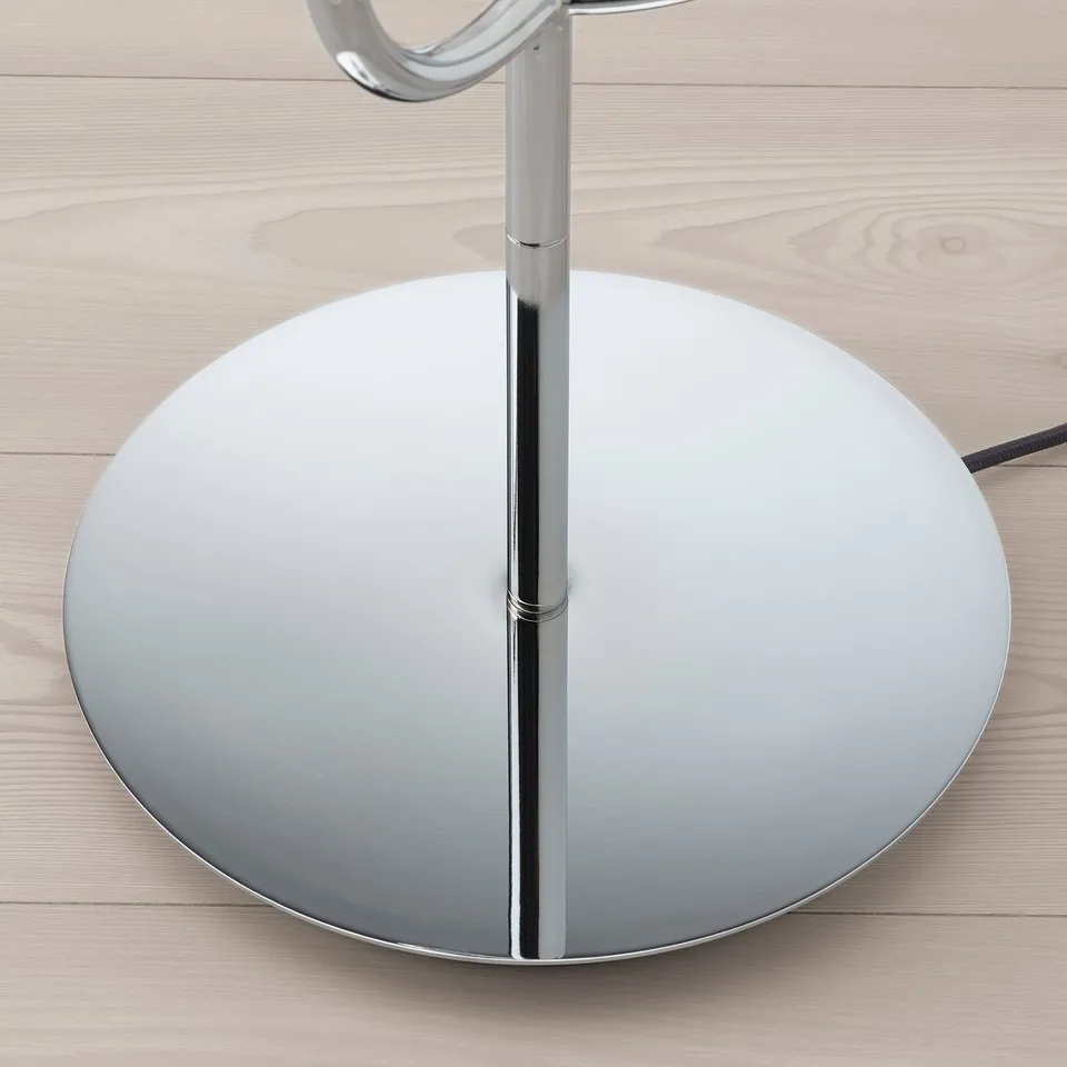Modern chrome lamp with sleek, round base. Elegant design for stylish home lighting.