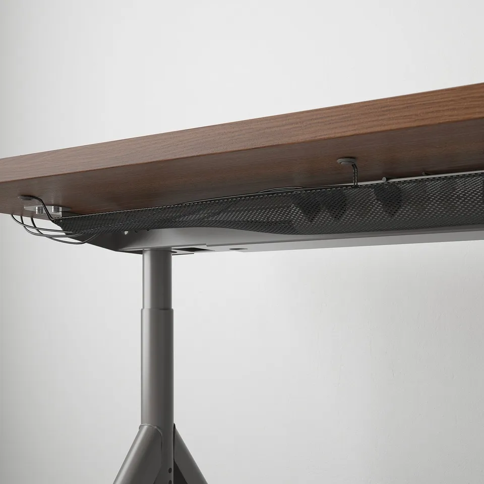 Close-up of sturdy, adjustable desk with cable management net.
