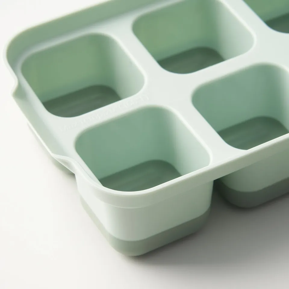 Ice cube tray with lid, white and light green. Flexible design, stackable, easy to remove cubes.