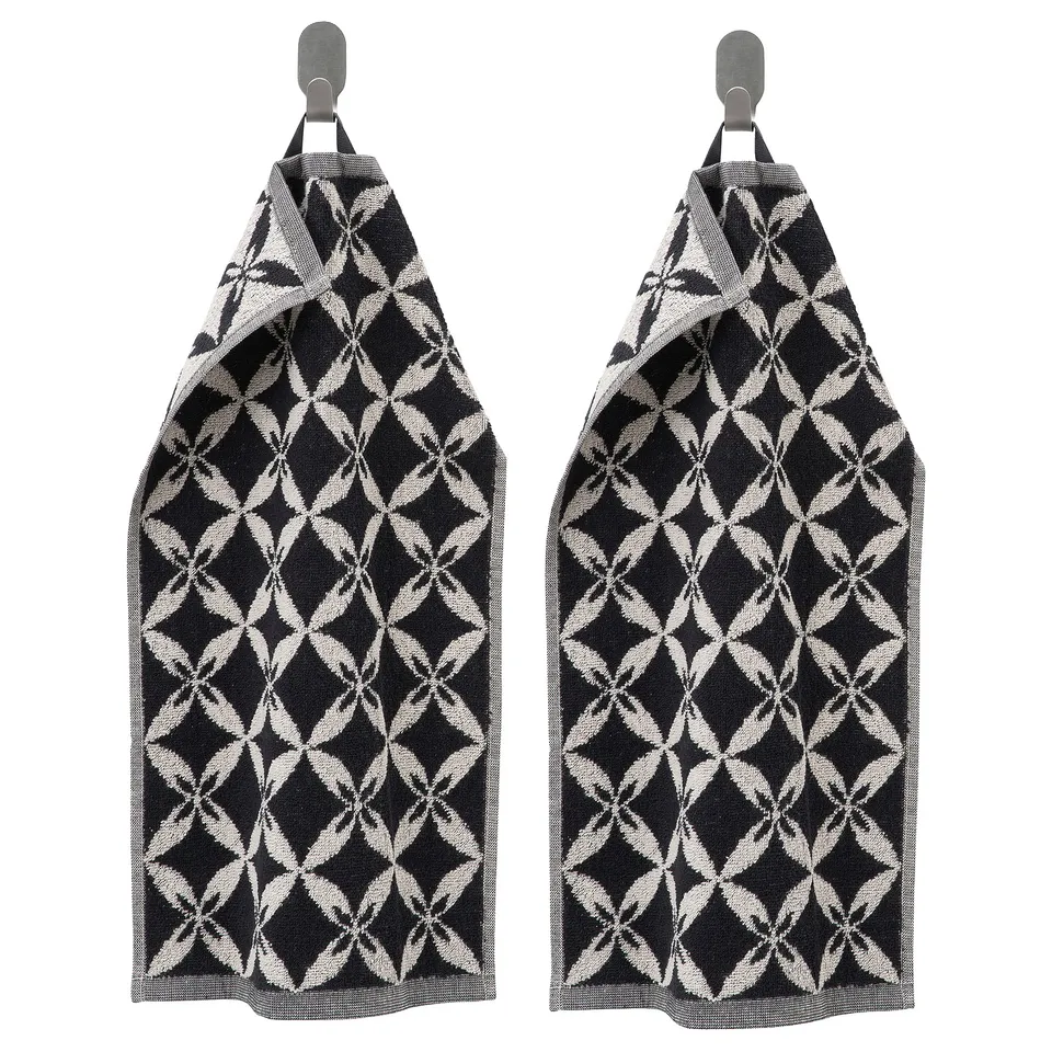 Two black-and-white patterned towels hang side by side, featuring geometric designs, rectangular shape, and cotton material.