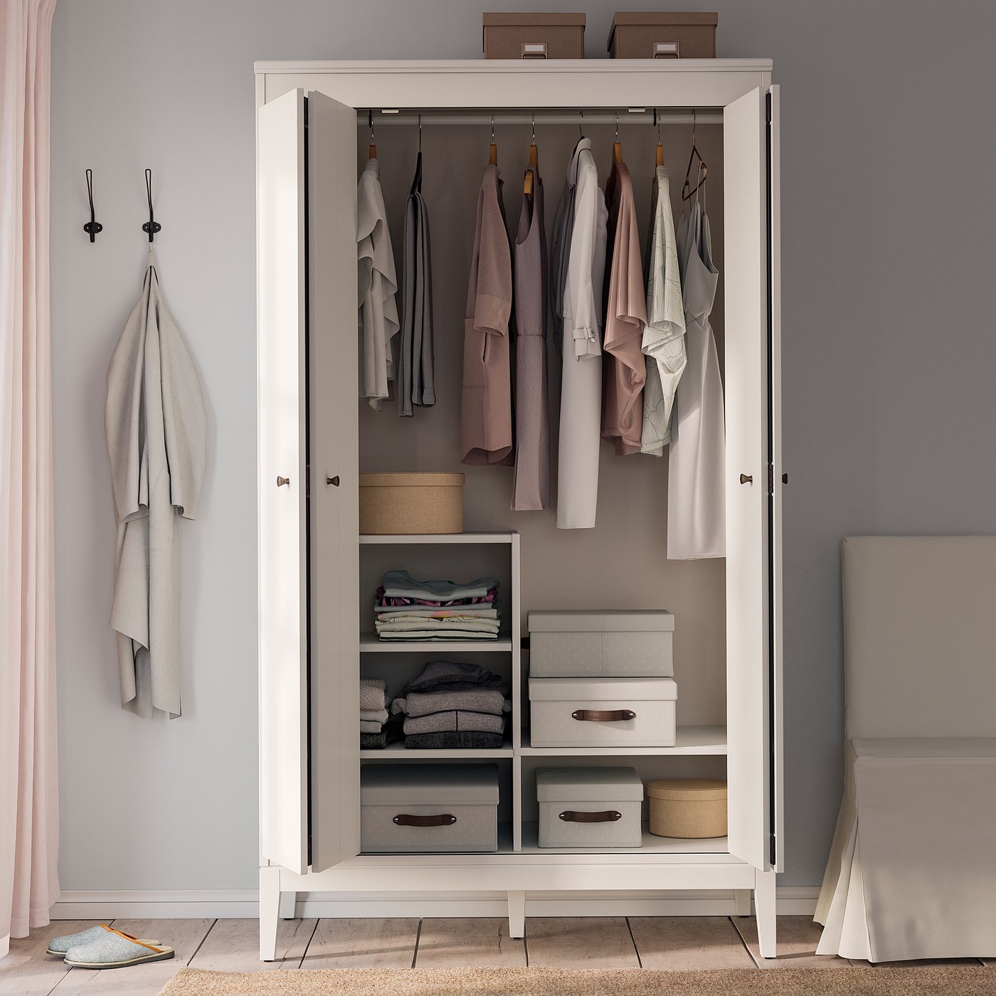 White IDANÄS wardrobe, open showing clothes and storage with shelves and boxes.