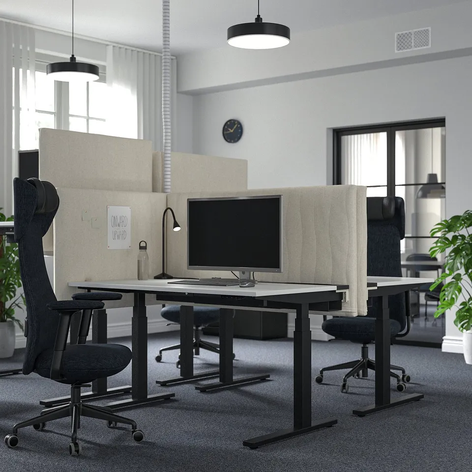 Modern MITTZON sit/stand desks with monitors, chairs, acoustic screens, and greenery.