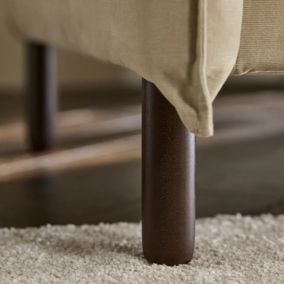 Modern sofa with comfortable cushions and sturdy wooden legs.
