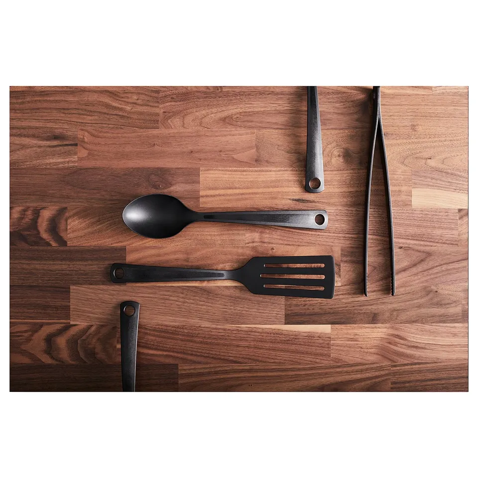 KARLBY walnut kitchen worktop display. Includes black utensils: spoon, spatula, tongs, and knife.